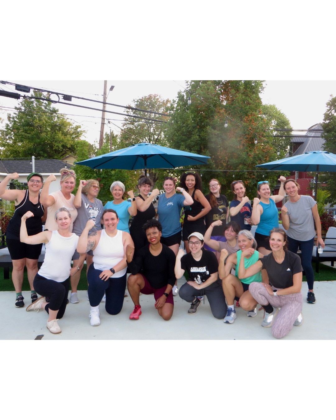 The Strength Initiative community — women flexing and celebrating together outdoors